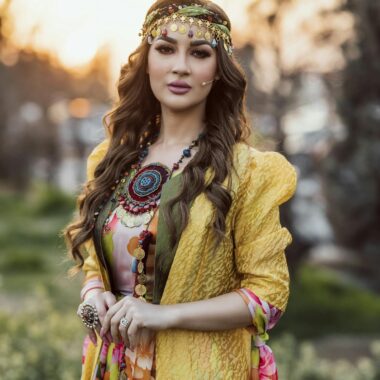 Portrait of a woman in colorful Kurdish attire at sunset in Erbil, Iraq