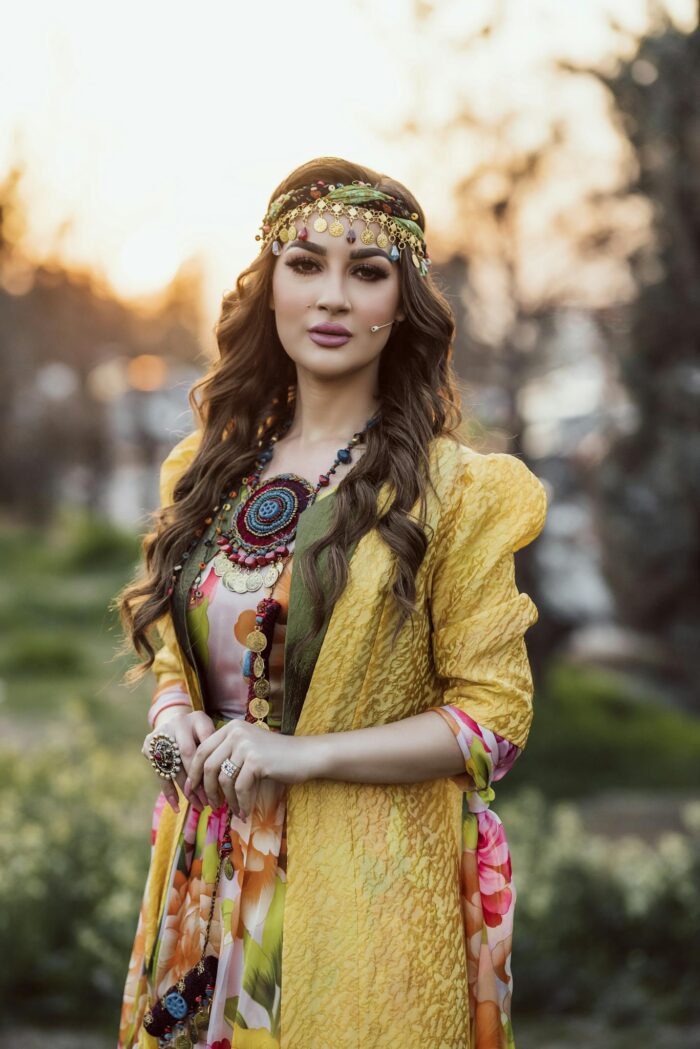 Portrait of a woman in colorful Kurdish attire at sunset in Erbil, Iraq